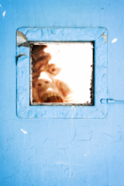 man in small window of steel-reinforced door