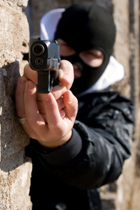 person in balaclava pointing gun