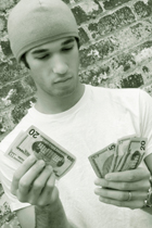 person counting money against a brick wall