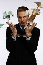 person in suit juggling money while wearing handcuffs