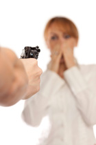 person pointing gun at woman in a white room
