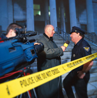 police officer being interviewed next to police tape