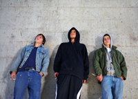 three people leaning against the wall looking threatening