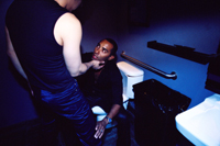 a person cupping another person's chin in a washroom