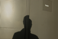 shadow of a person against a bathroom stall
