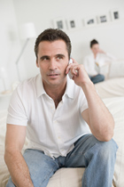 a person on a cell phone, another blurry in background