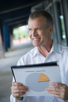a smiling person holds a pie chart