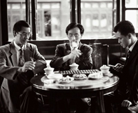 three people wearing suits and eating lunch