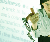 person dangles handcuffs, dictionary definition of business in background