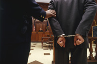 a person in a suit wears handcuffs
