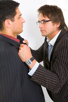 a person in a suit grasps another by the lapels